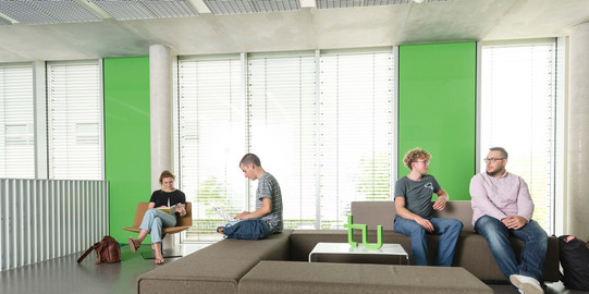 Four students are sitting on a sofa